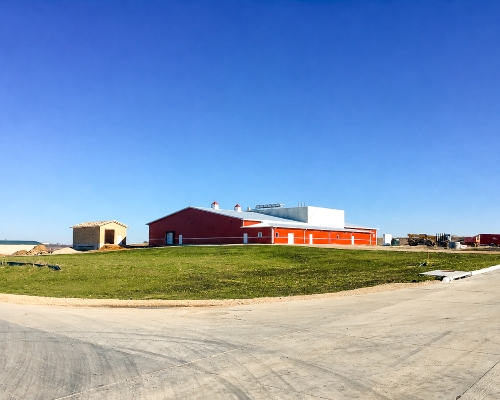 Upper Iowa Beef plant in 2016, blue skies, red walls, white roof. Green grass.