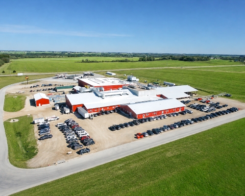 Upper Iowa Beef, green grass, Casey's. blue sky, red building with white roof. Cars in parking lot.