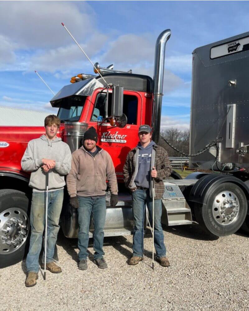 The Peterson Family in front of a semi