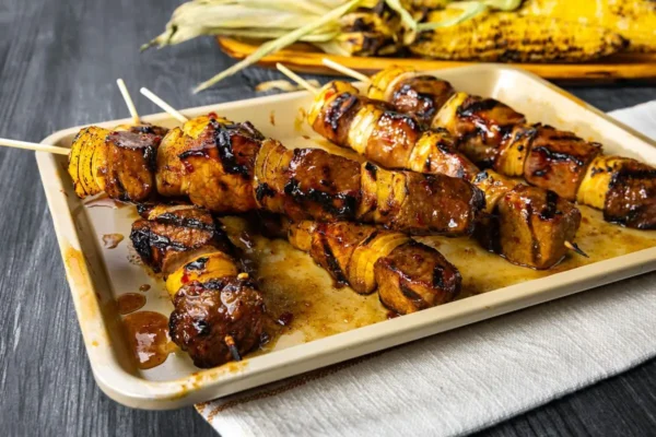 Beef Sosatie (Beef and Onion Kabobs), pan with food on table outdoors.